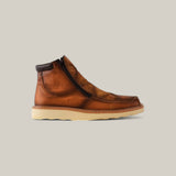 The Exotic Ostrich - Fawn Ankle Boot features fawn-colored ostrich leather, a dark brown padded ankle collar, a side zipper, and a beige rubber sole. The boot is set against a plain light gray background.