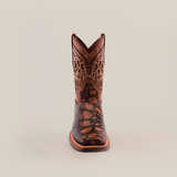 The Loggerhead Turtle Print brown Rodeo Toe cowboy boot boasts a detailed design with intricate shaft patterns and a rugged foot texture, all crafted from premium cowhide leather and showcased against a plain white background.