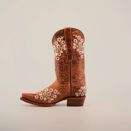 Against a white backdrop sits a single brown cowboy boot, adorned with white floral embroidery and crystal embellishments. This Western-style boot, echoing the Abril Crystals - Mid Shaft - Snip Toe design, features intricate stitching and a low heel.