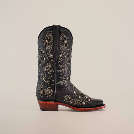 The Mayan Flower Crystals Black boot boasts intricate Mayan flower crystals and cream floral embroidery on black leather. It features a narrow square toe, a wooden heel, and detailed stitching on a plain white background, all handcrafted for artisanal elegance.