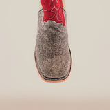 Introducing the Cowhide Hair Pinto Square Toe boot—a close-up reveals a gray textured leather foot with red embroidery on the upper. This design showcases a square toe with detailed sole stitching, perfectly blending rugged charm and refined craftsmanship.