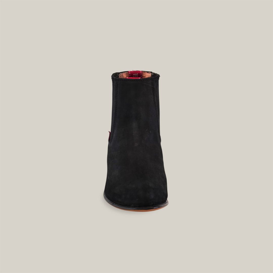 A front view of the Prime Suede Black Round Toe boot features a single black suede ankle design with a flat brown sole and round toe against a plain white background. Its absence of visible laces or zipper creates a sleek and minimalist style.