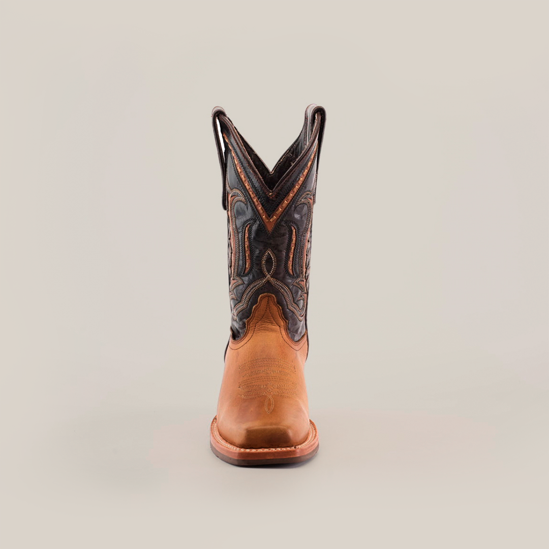 The Cater Honey Slip Resistant Sole Rodeo Toe boot features a premium leather foot and decorative black leather shaft against a plain white background, offering both style and function with its classic design suitable for any occasion.