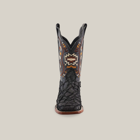 The Exotic Pirarucu Fish Patchwork Matte Black Square Toe boot features intricate orange, brown, and white embroidery. Crafted from authentic leather, it boasts a textured lower section with contrasting shaft stitching against a plain white backdrop.