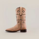 The Palles Aztec Stitch Fawn boot features a tan color, Aztec-inspired brown and teal geometric stitching on the shaft, a square toe, and a dark heel, set against a plain white background.