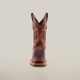 A single Azkar Moka cowboy boot with a pointed rodeo toe is showcased against a white background. It features intricate stitching, a stacked heel, decorative patterns along the shaft, and a slip-resistant sole for added stability.