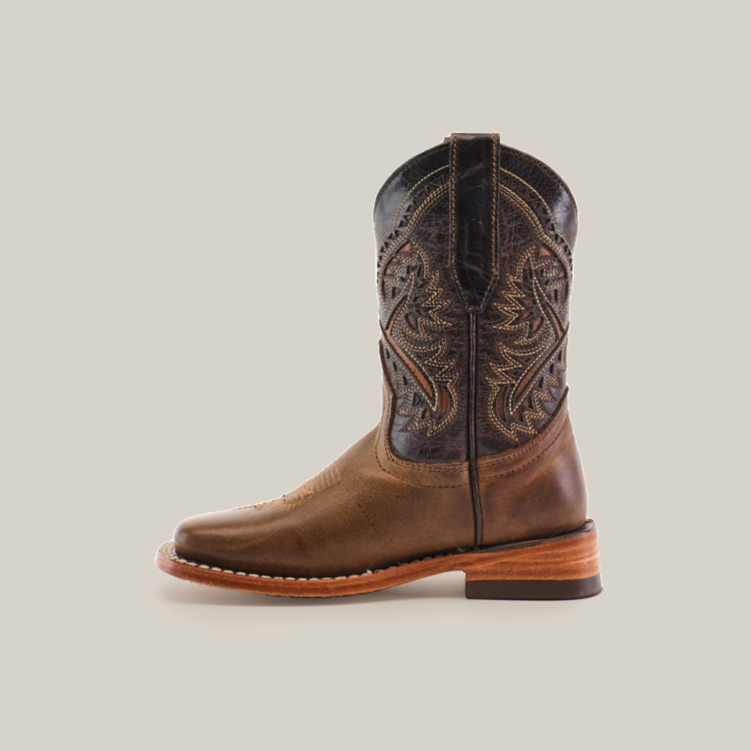 The Ranch Camel Square Toe boot, made from cowhide leather, features intricate shaft stitching and patterns, a wooden heel, and a rounded toe. Displayed on a white background, it exudes western elegance.