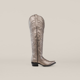 Against a plain gray background, the Taylor Mercury - Tall Shaft - Snip Toe cowboy boot stands out with intricate swirling patterns, a metallic silver finish, and a leather sole, showcasing elegance and craftsmanship.