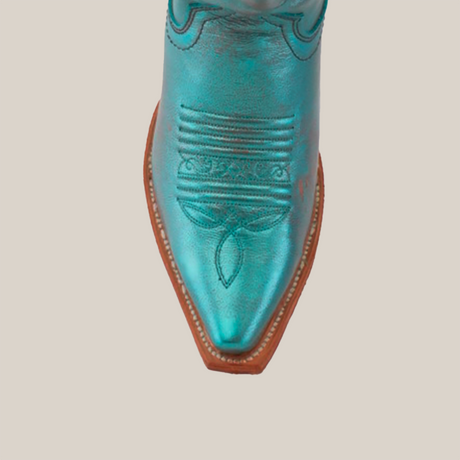 Close-up of a turquoise Brittany Rustic Ceramic Tall Shaft Snip Toe Boot showcasing detailed toe stitching, a pointed shape, and a light brown genuine leather sole. The handcrafted boot is set against a plain white background.