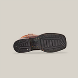 The image displays the Azkar Moka shoe horizontally, highlighting its detailed tread pattern and slip-resistant sole for improved grip. A logo is centered on the brown shoes sole against a plain backdrop, merging style with functionality in its square-toe design.