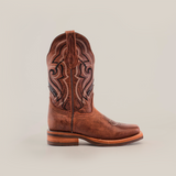 The Fresno Shedron Cowboy Boot features a detailed stitched design on the shaft and stands against a plain white background. With a rodeo toe, rounded design, and slip-resistant sole, it combines style and functionality with its wooden heel.