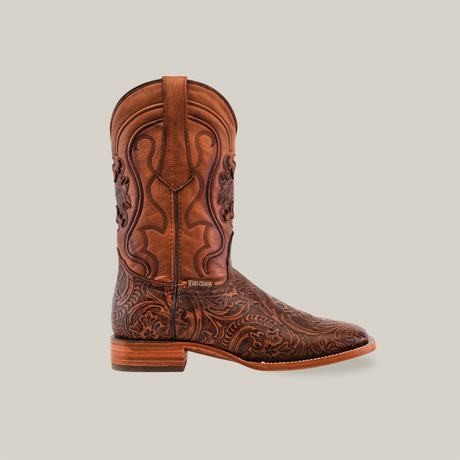 The Handtooled Leave Brown - Square Toe cowboy boots showcase intricate floral embossing on premium cowhide leather, with a square toe and flat heel, set elegantly against a plain white background.