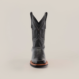 A single black cowboy boot, crafted from premium leather with intricate stitching and a pointed toe, features a Barcelona Black Slip Resistant Sole, captured from the front against a plain white background.