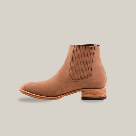 The Prime Suede Sand Square Toe boot is a tan leather Chelsea style featuring an elastic side panel, a wooden heel, subtle stitching, and a slightly pointed toe. It embodies the Cowboy Fashion trend against a plain white backdrop.