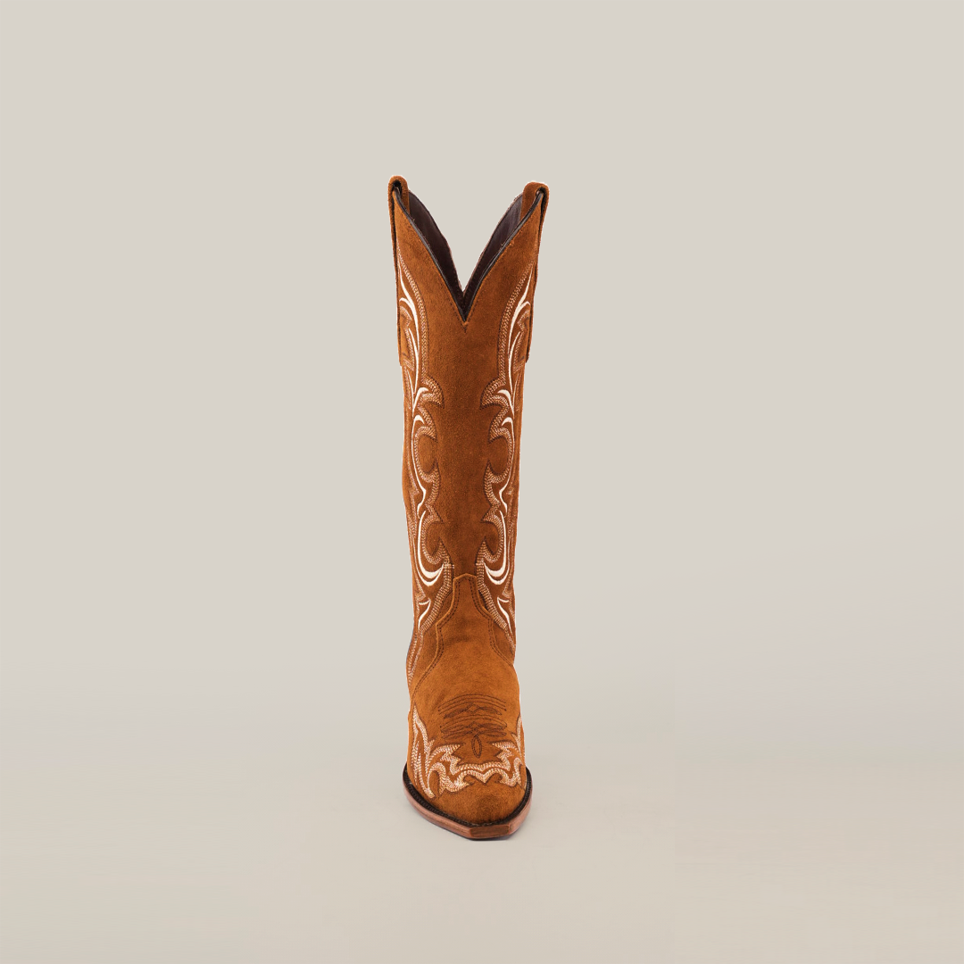 A single brown Amara Tabaco Suede boot with intricate white embroidery on the shaft is displayed against a white background. This elegant womens boot features a snip toe and slight heel, epitomizing timeless style.