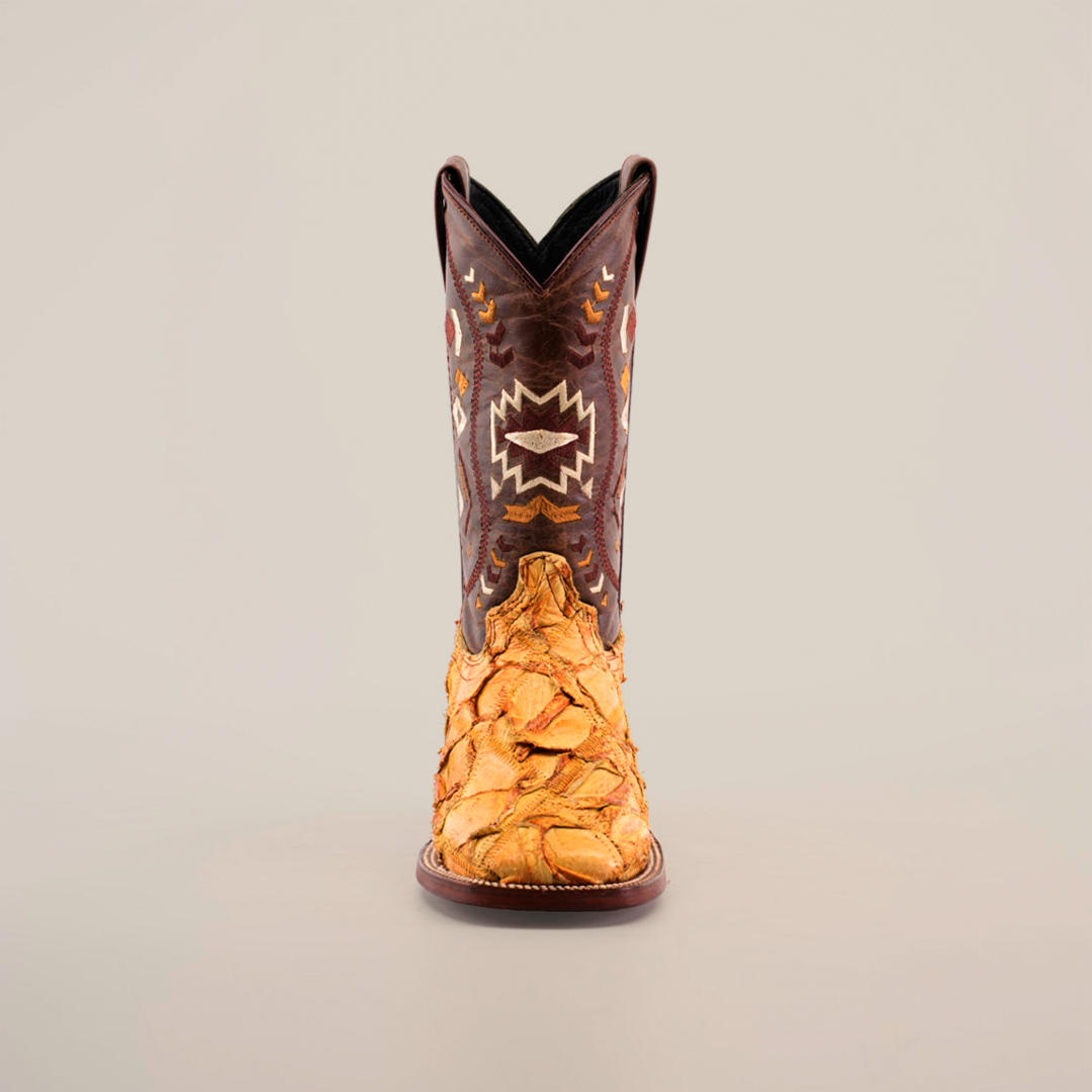 Front view of the Exotic Pirarucu Fish Patchwork Honey Square Toe boot, featuring a brown upper with white and orange geometric embroidery and a tan leather lower part with textured Pirarucu fish scale design against a plain white background.