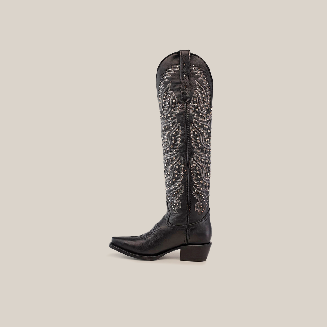 The Crystals Wings Black Lustre boots feature a tall shaft with intricate silver embroidery and decorative studs. Handcrafted with a premium leather sole, these cowboy boots boast a snip toe and medium stacked heel, elegantly showcased in side profile on a white background.