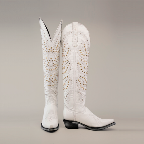 The Crystals Wings Frost White boots have a tall shaft and snip toe with intricate gold stud detailing, embroidery, and classic western-style stitching. The left boot is upright, while the right leans slightly.