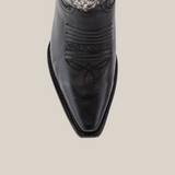 A close-up of the snip toe on the Crystals Wings Black Lustre boot reveals intricate stitched patterns with symmetrical geometric shapes, adding texture to the handcrafted smooth leather surface complete with a premium leather sole.