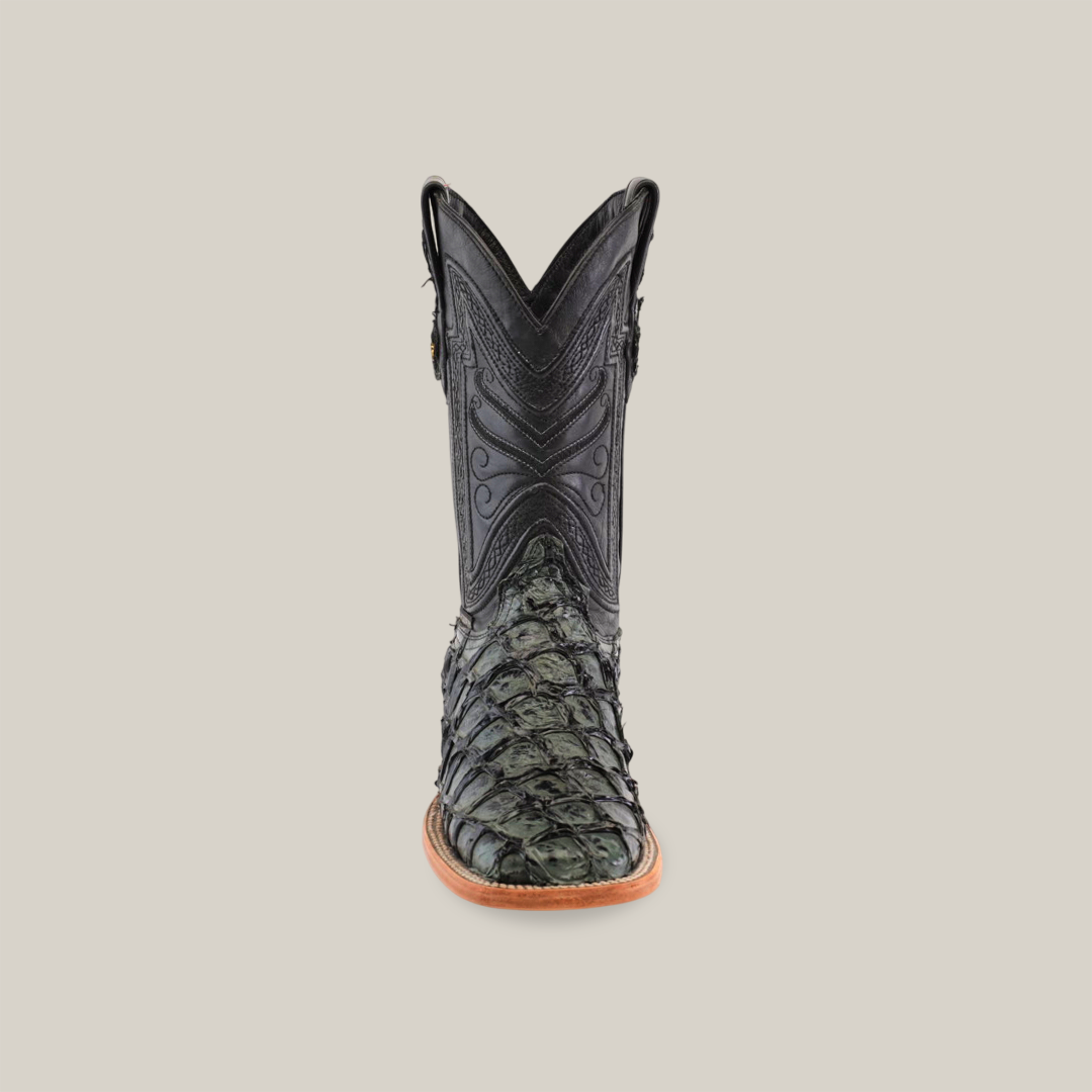 The Exotic Piraruco Fish - Charcoal- Square Toe is a stylish cowboy boot for fashion lovers, featuring a dark, intricately designed leather upper made from Piraruco fish leather. It has textured patterns on the lower part with a pointed toe and light brown sole, all on a plain white background.