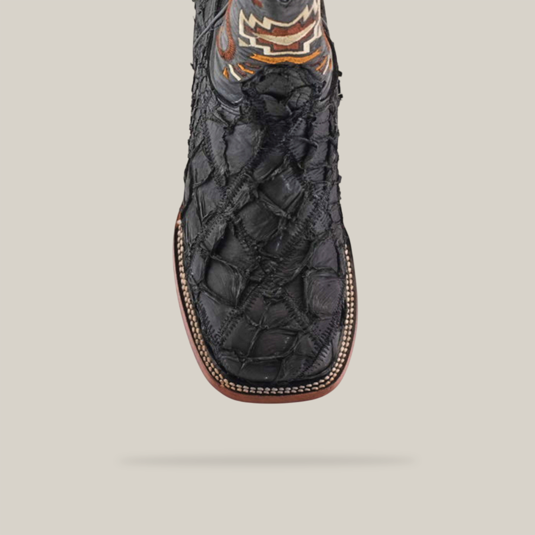 Close-up of the Exotic Pirarucu Fish Patchwork Matte Black Square Toe boot, flaunting an intricate texture and a colorful geometric design in brown, orange, and white on top, adding contrast to the authentic leather.