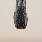 The Caiman Hornback Print Black Square Toe boot features a textured black leather with a square toe and stitched edging, crafted from premium materials, set on a plain light background.