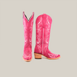 The Amara Pink Suede boots feature a tall shaft, intricate white stitching, and a snip toe. The left boot stands upright while the right displays its side profile with a wooden heel, all set against a white background. They embody classic Western style.