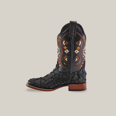 The Exotic Pirarucu Fish Patchwork Matte Black Square Toe boot combines genuine leather with elaborate colorful patterns on the upper shaft. It showcases a textured surface, a wooden sole with stacked heel, and is photographed against a plain white background.