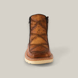 A single Exotic Ostrich - Fawn ankle boot, brown with an ostrich pattern on the toe and shaft, front view against a plain fawn background. It has black stitching and a light-colored sole.