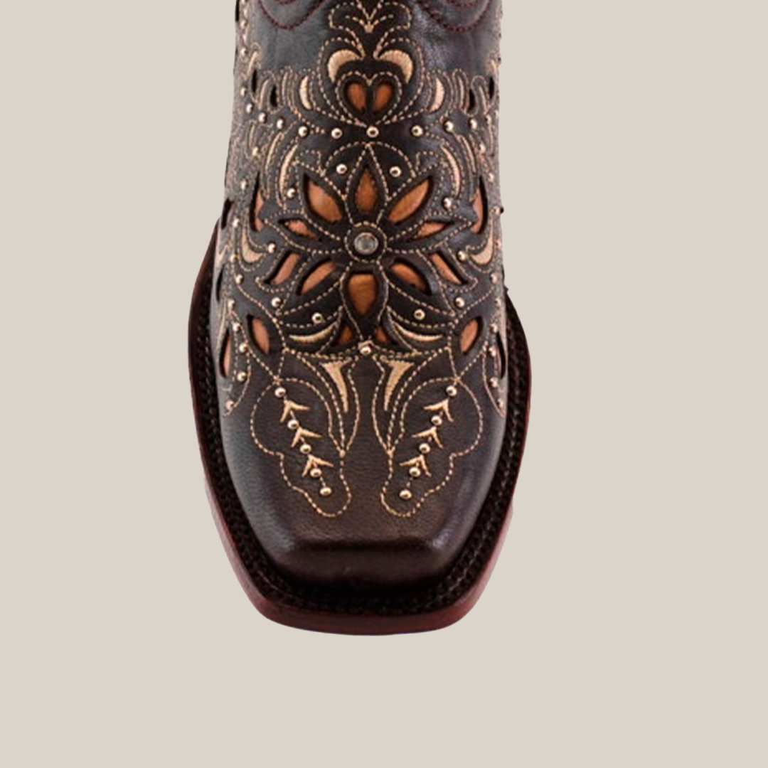 The Kiara Crystals Chocolate Mid Shaft boot features intricate floral and swirl laser-cut designs on premium brown leather, highlighted by a narrow square toe and decorative beige stitching, all elegantly showcased against a white background.