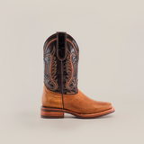 A single Cater Honey Slip Resistant Sole Rodeo Toe boot is showcased against a white background, highlighting its intricate brown stitching and dark leather accents. Crafted from premium leather, it features a wooden heel, detailed embroidery, and a slip-resistant sole for added stability.