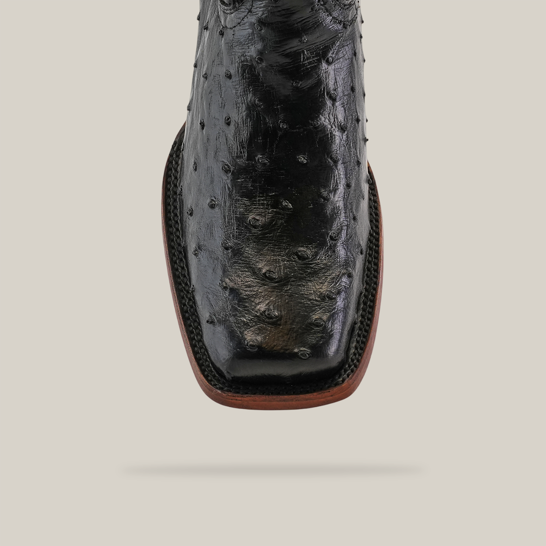 Close-up of the Exotic Ostrich - Black boot with a Rodeo Toe, crafted from genuine ostrich leather, highlighting its characteristic textured bumps against a simple background.