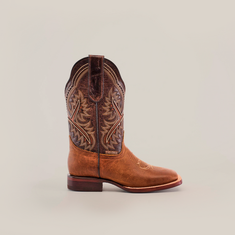 The Cater Honey Square Toe boot is crafted from premium leather with intricate stitching on the shaft in a dark brown and tan color scheme, featuring a square toe and low heel to embody superior craftsmanship against a plain white background.