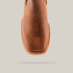 Top view of an Avejentado Honey square toe ankle boot in rich brown leather with intricate stitching framing the toe and edges. Set against a white background, this boot embodies classic cowboy charm and style.