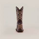 The Maya Brown - Short Shaft - Square Toe boot is a single cowboy boot made from premium leather, featuring intricate beige and brown geometric patterns on a light background with distinctive stitching.