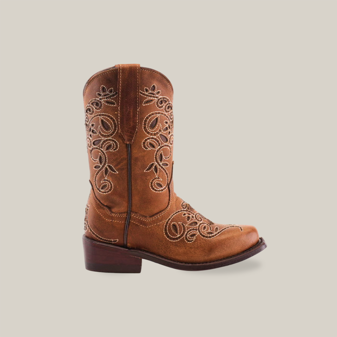 The Carola Tabaco - Snip Toe boots feature a brown design crafted from premium cowhide leather with intricate white embroidery on the shaft and toe, complemented by a low wooden heel, all set against a plain white background.