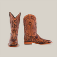 A pair of Handtooled Leave Orix - Square Toe brown cowboy boots features intricate cowhide craftsmanship. One boot stands upright, the other tilts to display their design against a white background.