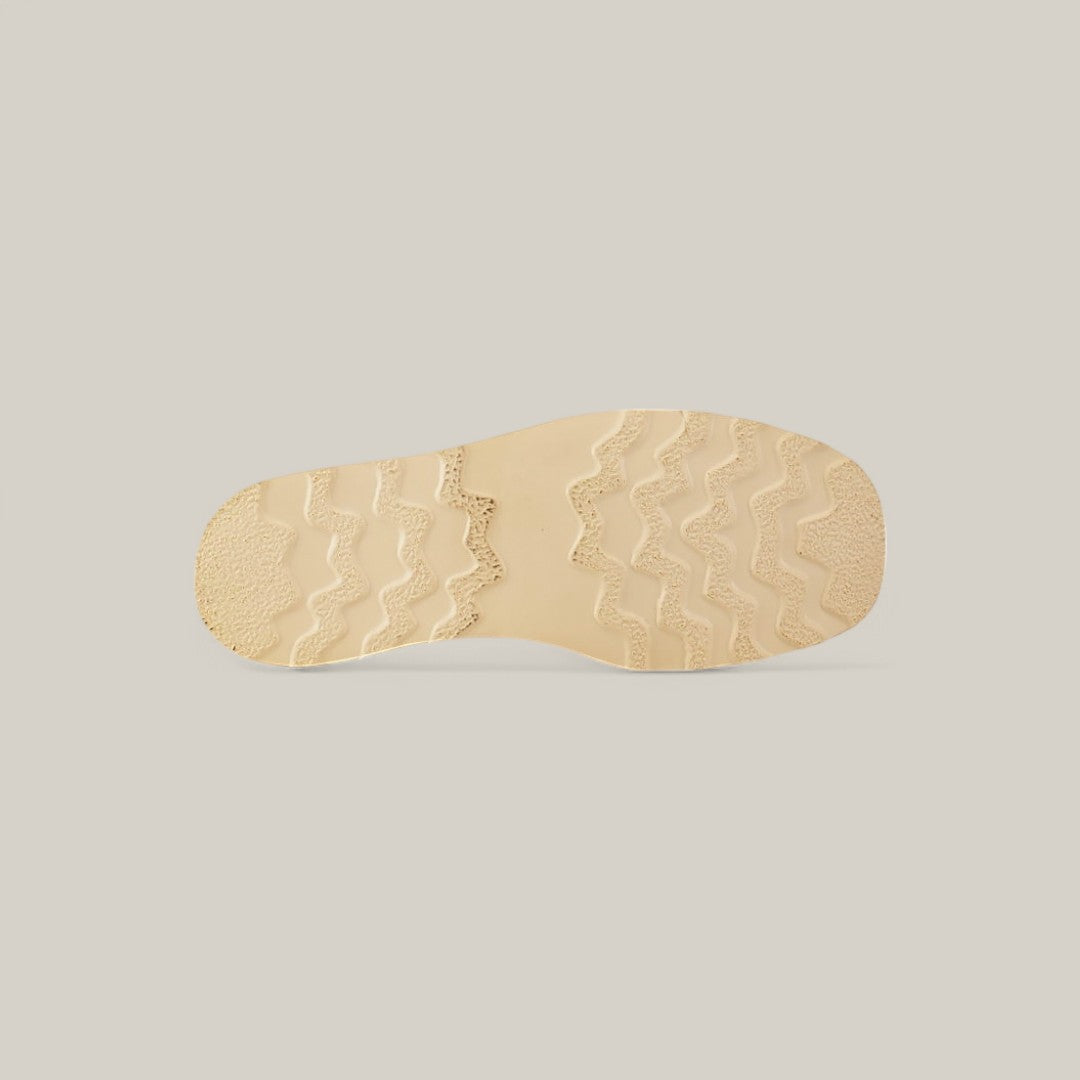 The image showcases the Exotic Ostrich - Fawn - Ankle Boots sole against a plain backdrop. The fawn-colored sole features a wavy texture for grip, with a rougher heel area for traction, exuding elegance akin to ostrich leather.