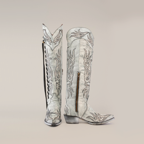 Tall cowboy boots with intricate gray and white embroidery, the Emma Alaska Black - Tall Shaft - Snip Toe, embody Western heritage. Featuring side zippers and a low heel, theyre elegantly showcased against a plain white background, reflecting true craftsmanship.