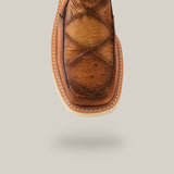 Close-up of the Exotic Ostrich - Fawn - Ankle Boot, featuring brown ostrich leather with a crisscross toe pattern, thick sole, visible stitching, and slightly lifted on a light gray background.