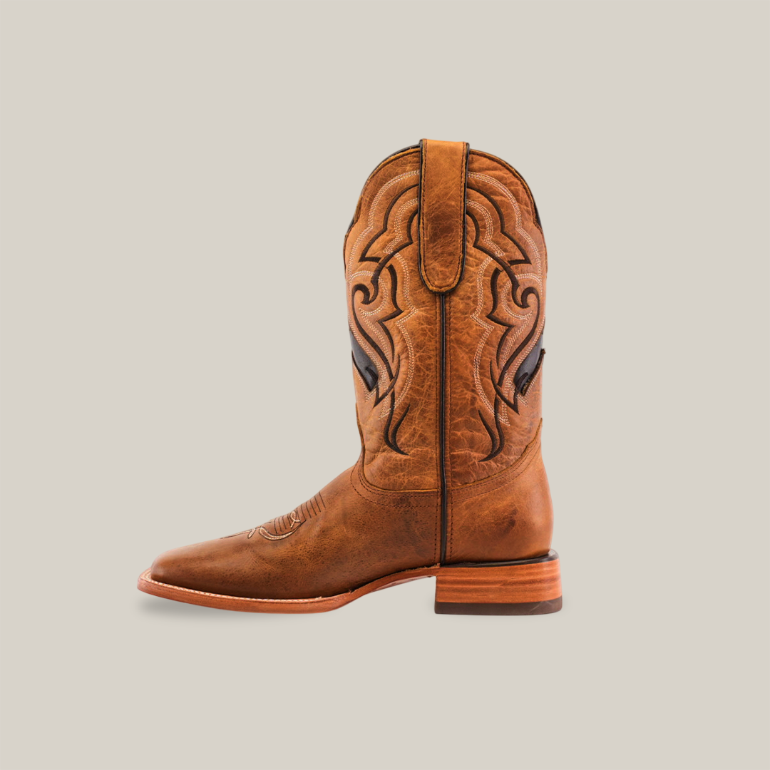 The Wild Mustard - Square Toe cowboy boot, made from premium cowhide in brown, features intricate stitching on the shaft and a genuine leather sole. Perfectly upright against a plain white background, it showcases a slightly worn look.